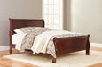 Ashley Furniture Alisdair Bed with a sturdy wooden frame and upholstered headboard, showcasing a modern bedroom design.