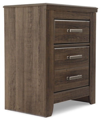 Ashley Furniture Juararo nightstand with a dark wood finish and modern design, shown from an angled side view.